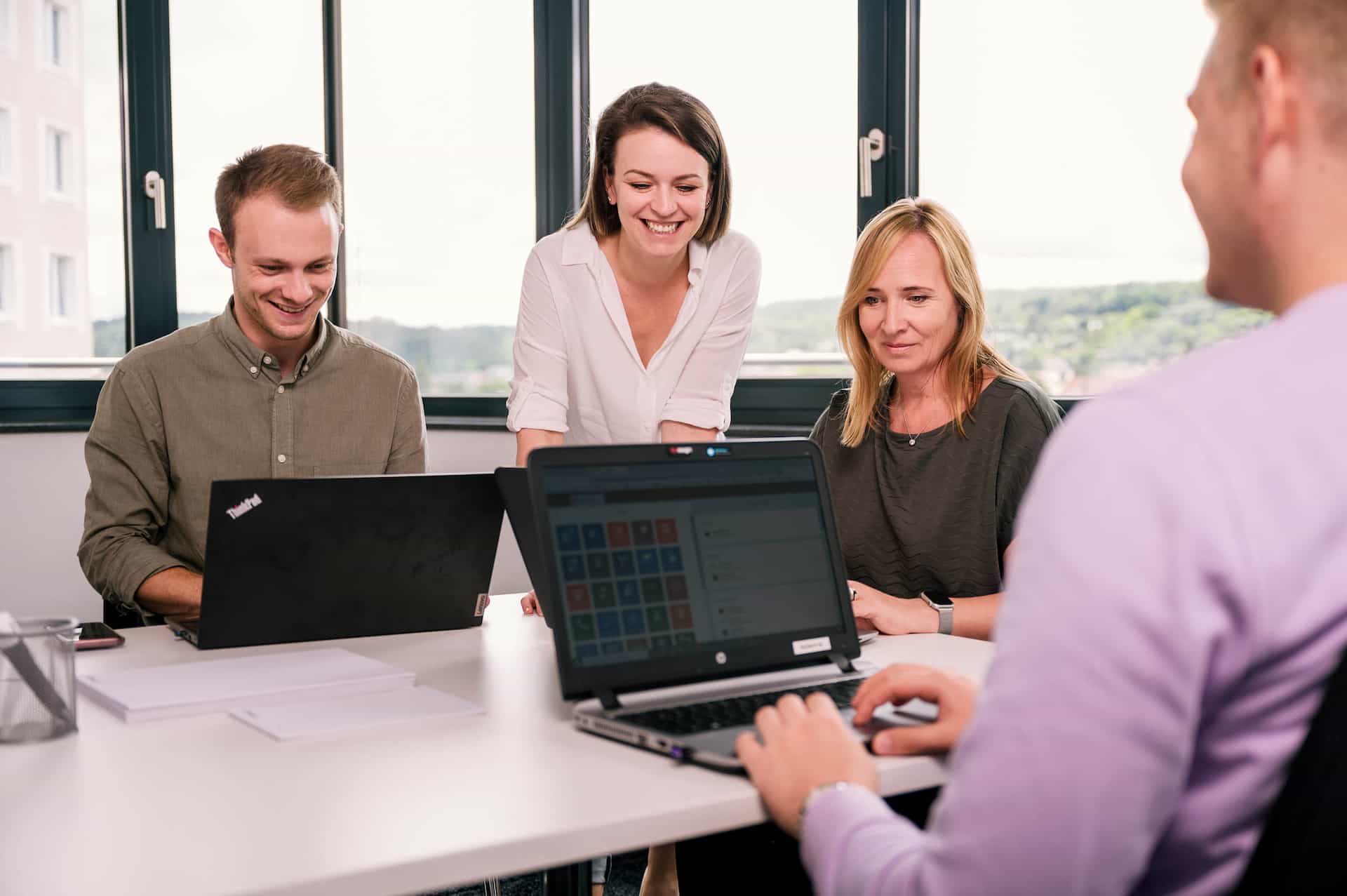 Menschen arbeiten gemeinsam an Laptops